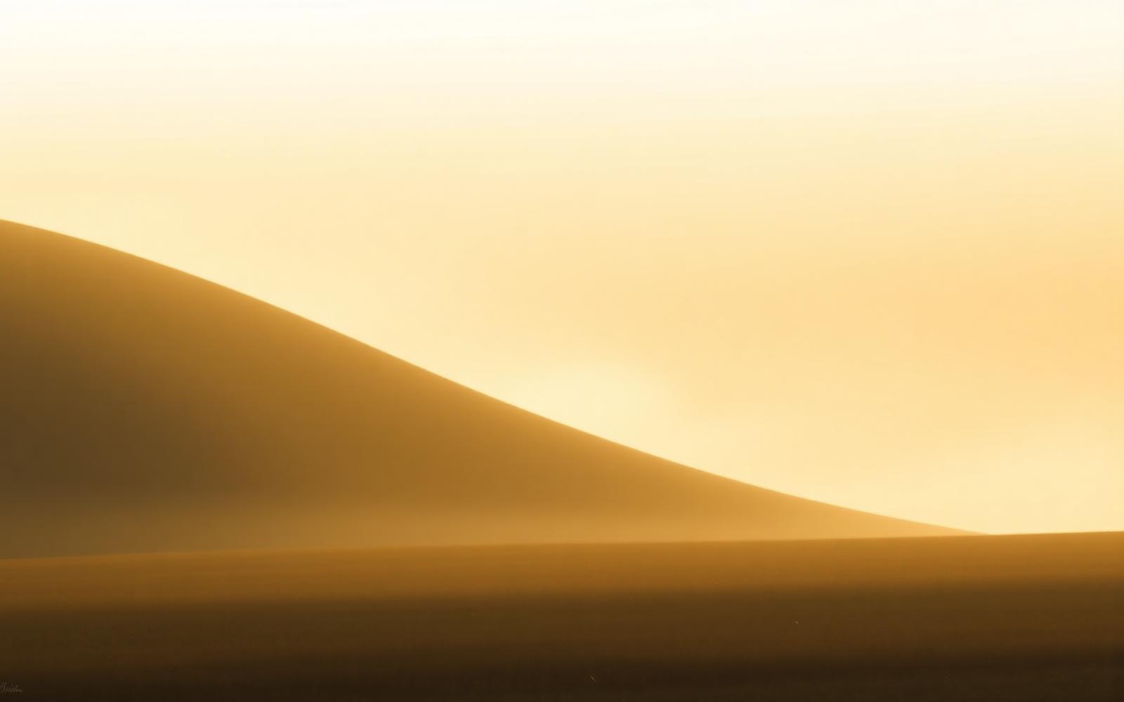 Dawn light rising over a quiet hillside